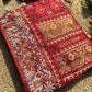 Royal Red Patola-Inspired Designer Saree with Golden Zari-Style Border, Multicolour Floral Motifs, Intricate White Beadwork and Pearl Tassel Detailing