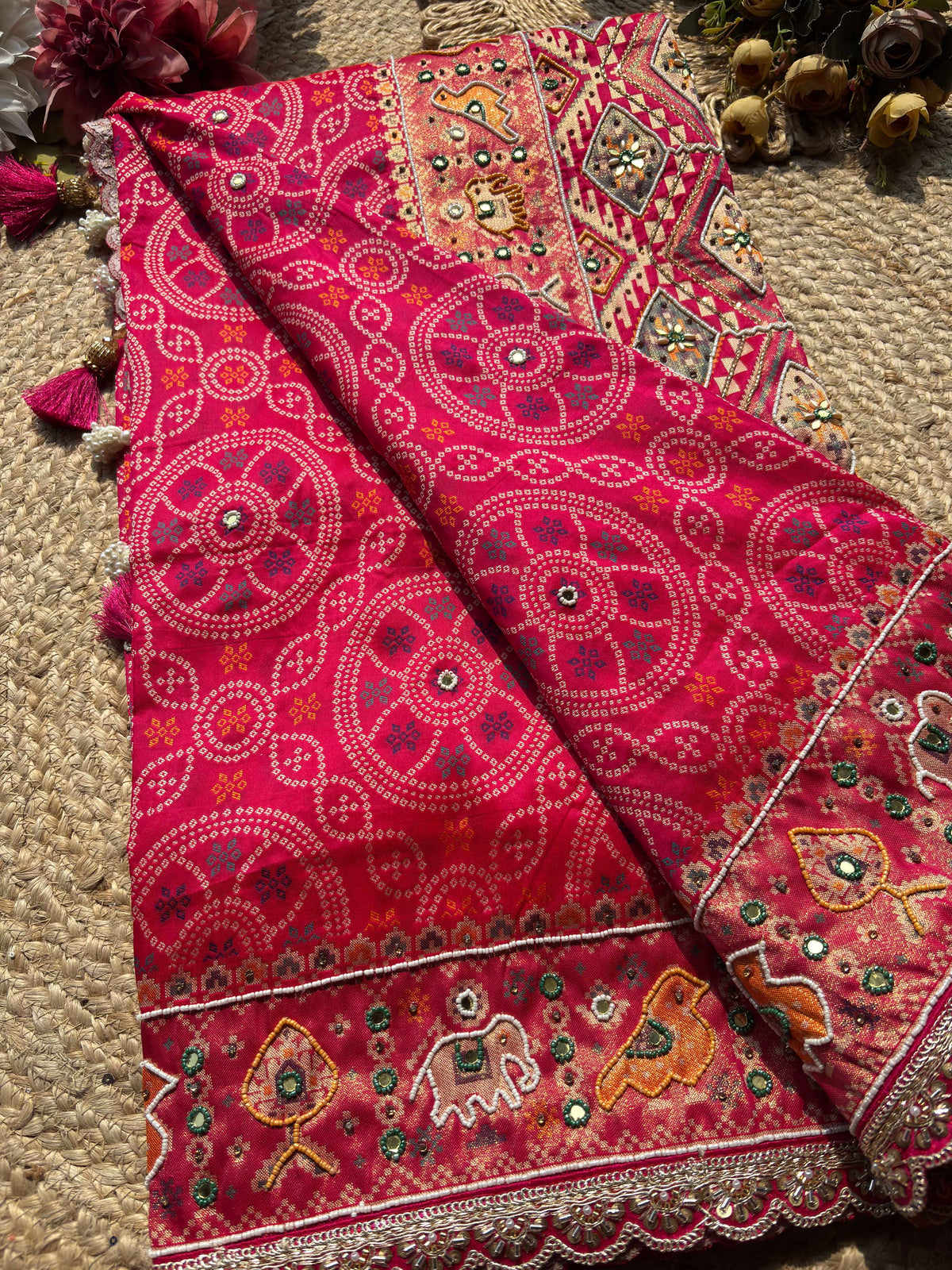 Rani Pink Bandhani Designer Saree with Traditional Elephant Motifs, Intricate Pearl Beadwork, Mirror Embellishments, Gold Zari Detailing and Scalloped Lace Border